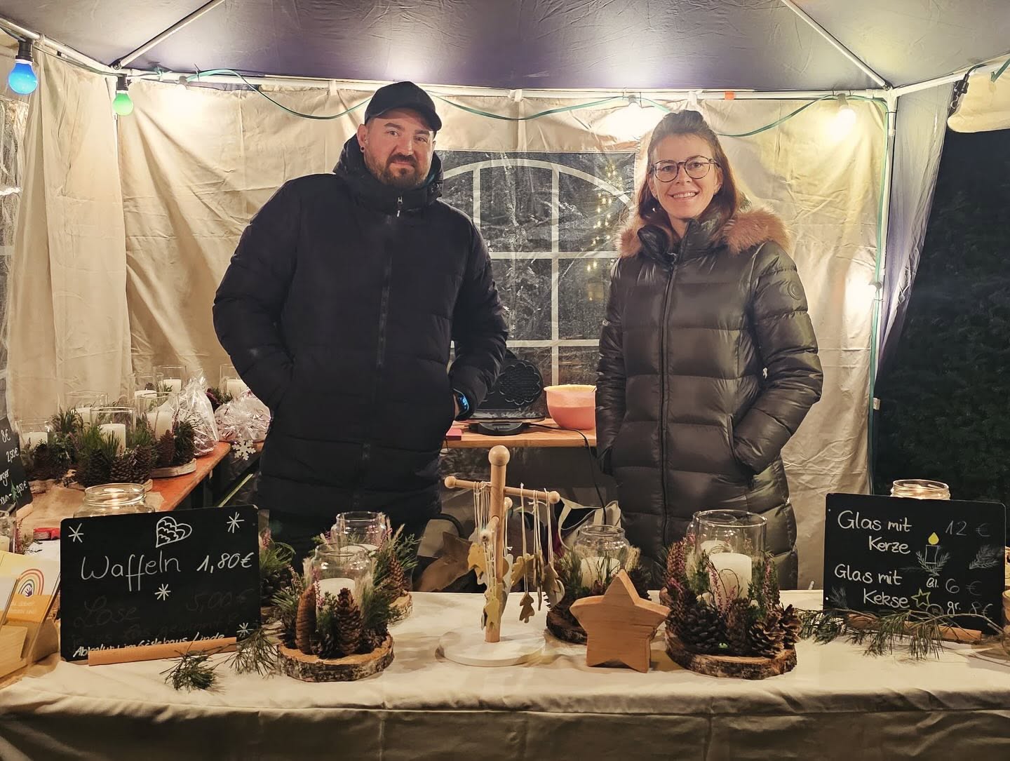 Weihnachtsmarkt-Stand mit selbstgebastelten Kerzen und Waffeln